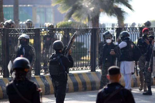 A police officer fires warning shots in the air during clashes with supporters of imprisoned former premier Imran Khan's Pakistan Tehreek-e-Insaf party, in Islamabad, Pakistan, Tuesday, Nov. 26, 2024. (AP Photo/W.K. Yousufzai)