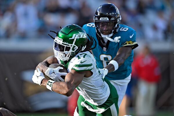 New York Jets wide receiver Davante Adams (17) scores ahead of Jacksonville Jaguars safety Darnell Savage (6) on a 71-yard touchdown reception during the second half of an NFL football game Sunday, Dec. 15, 2024, in Jacksonville, Fla. (AP Photo/Phelan M. Ebenhack)