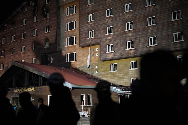 Tightened bed sheets hang from a window of a hotel where a fire broke out at the Kartalkaya ski resort in Bolu province, northwest Turkey, Tuesday, Jan. 21, 2025. (AP Photo/Francisco Seco)