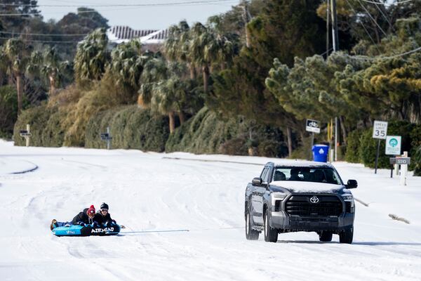 People take advantage of the snow on the H.L. Hunley bridge after a winter storm dropped ice and snow Wednesday, Jan. 22, 2025, on the Isle of Palms, S.C. (AP Photo/Mic Smith)