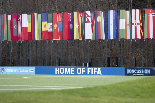 A soccer pitch with flags of the member states in the background is seen at the headquarters of the soccer association FIFA in Zurich, Switzerland, Wednesday, Dec. 11, 2024. (Til Buergy/Keystone via AP)