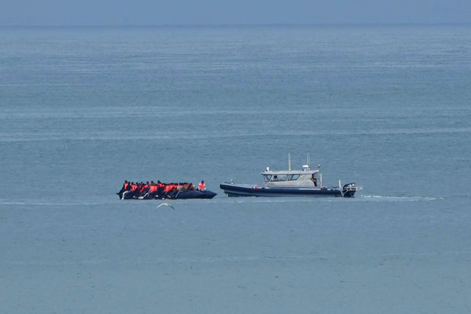 FILE - A boat thought to carry migrants is escorted by a vessel from the French Gendarmerie Nationale in the English Channel off Wimereux beach, France, Wednesday, Sept. 4, 2024. (AP Photo/Nicolas Garriga, File)