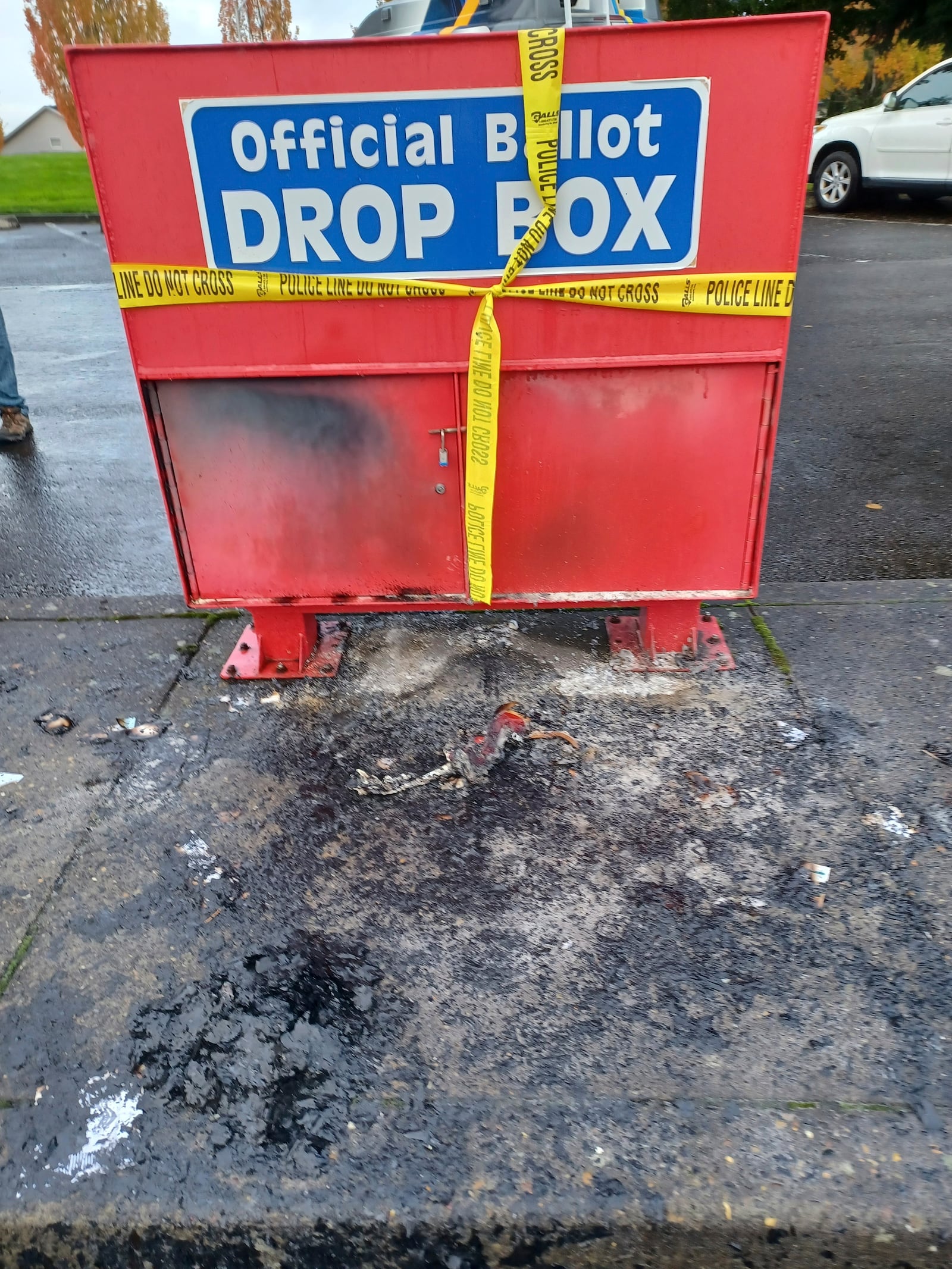 Police tape surrounds a ballot drop box damaged by a fire on Monday, Oct. 28, 2024, in Vancouver, Wash. (Monika Spykerman/The Columbian via AP)