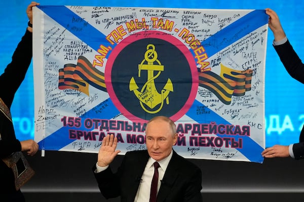 Russian President Vladimir Putin speaks during his annual news conference and call-in show at Gostinny Dvor in Moscow, Russia, Thursday, Dec. 19, 2024, as men hold a replica of the banner of the 155th Marine Brigade of the Pacific Fleet, participating in a special military operation in Ukraine in the background. (AP Photo/Alexander Zemlianichenko)