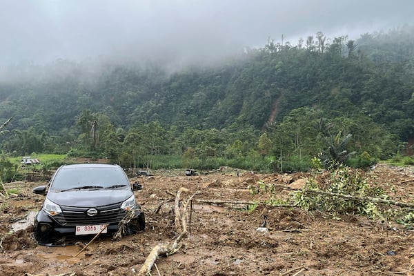 The wreckage of a car is stuck in the mud at an area affected by a landslide following a flash flood which killed a number of people in Pekalongan, Central Java, Indonesia, Wednesday, Jan. 22, 2025. (AP Photo/Janaki DM)