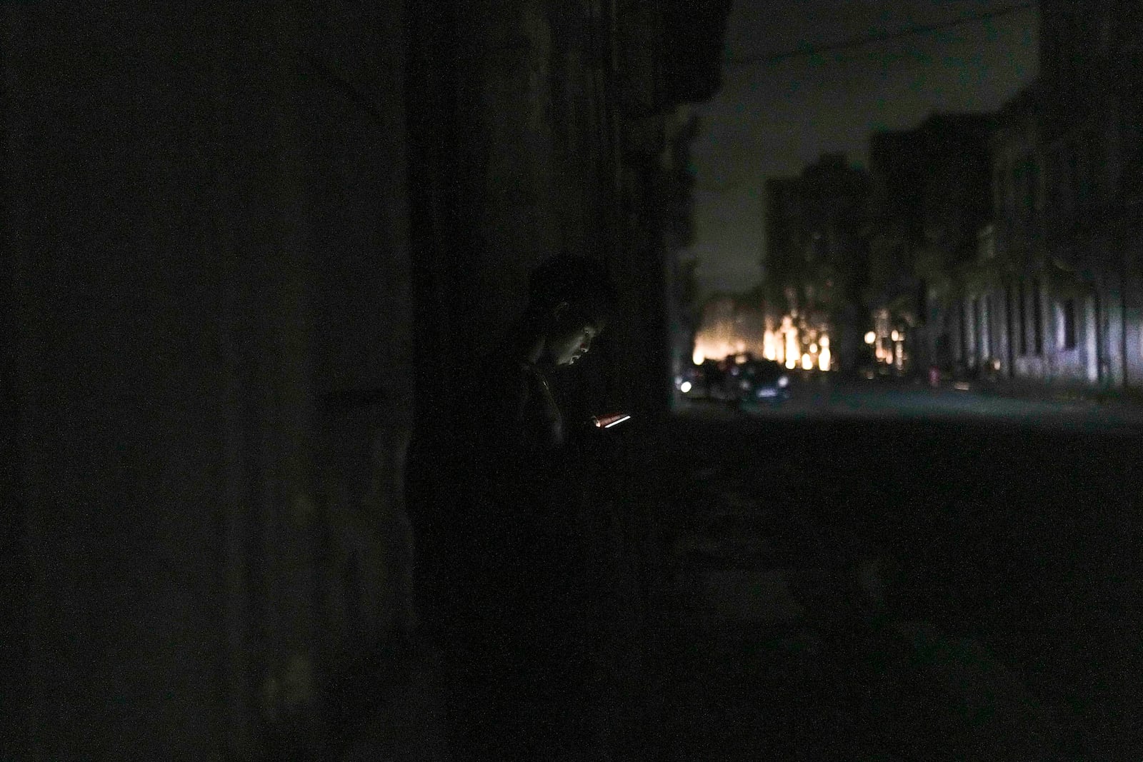 A man looks at his phone during a massive blackout after a major power plant failed in Havana, Cuba, Friday, Oct. 18, 2024. (AP Photo/Ramon Espinosa)