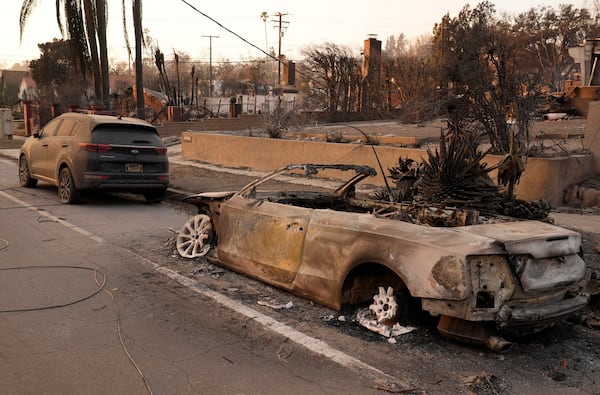 A car at right destroyed by the Eaton Fire sits next to an intact car, Thursday, Jan. 9, 2025, in Altadena, Calif. (AP Photo/Chris Pizzello)