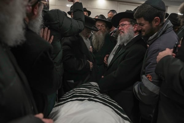 The body of Israeli-Moldovan rabbi Zvi Kogan is carried into a funeral home before his burial in Jerusalem, Monday Nov. 25, 2024. Kogan, 28, an ultra-Orthodox rabbi, was killed last week in Dubai where he ran a kosher grocery store. Israelis have flocked for commerce and tourism since the two countries forged diplomatic ties in the 2020 Abraham Accords.(AP Photo/Mahmoud Illean)