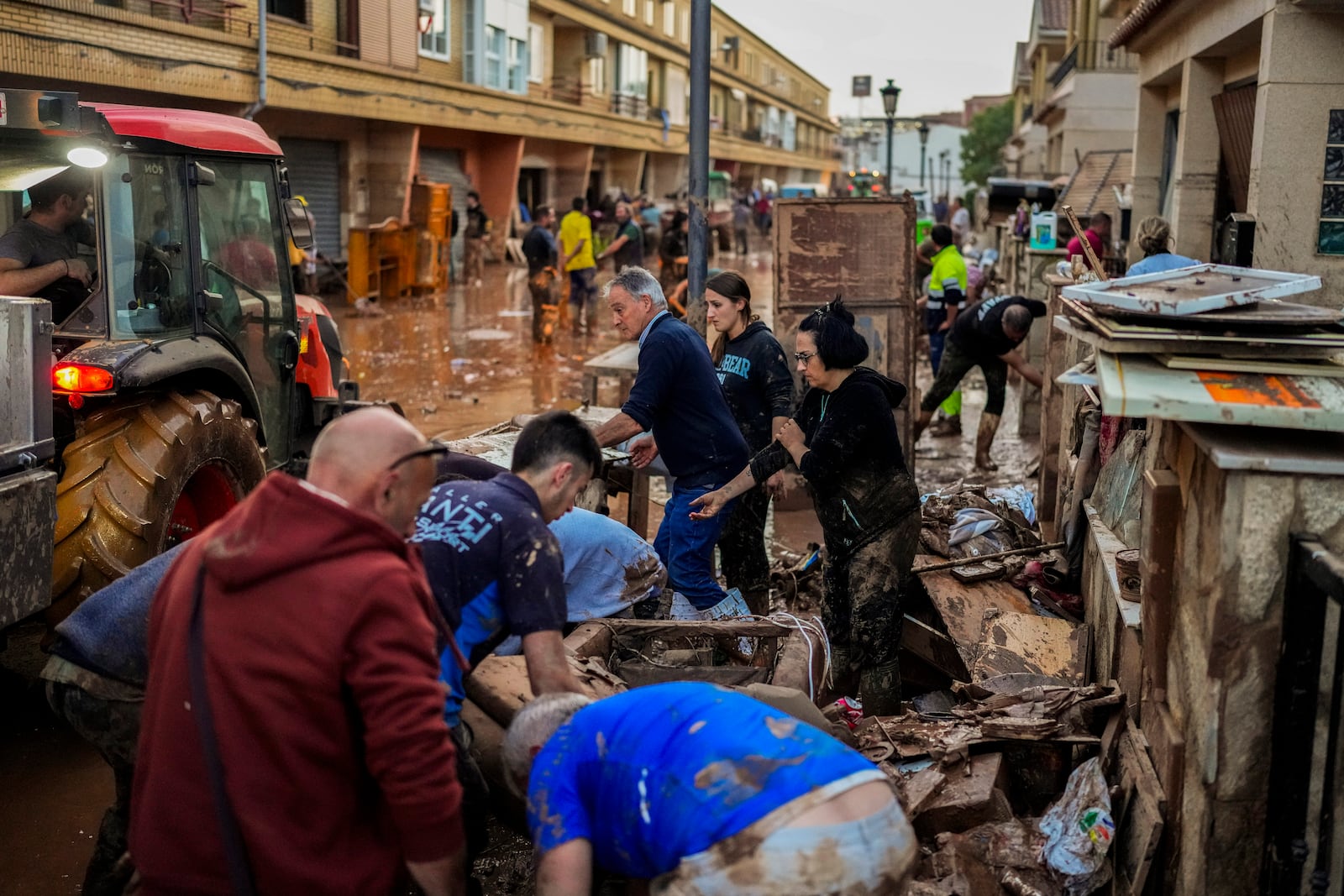 People clean their houses affected by floods in Utiel, Spain, Wednesday, Oct. 30, 2024. (AP Photo/Manu Fernandez)