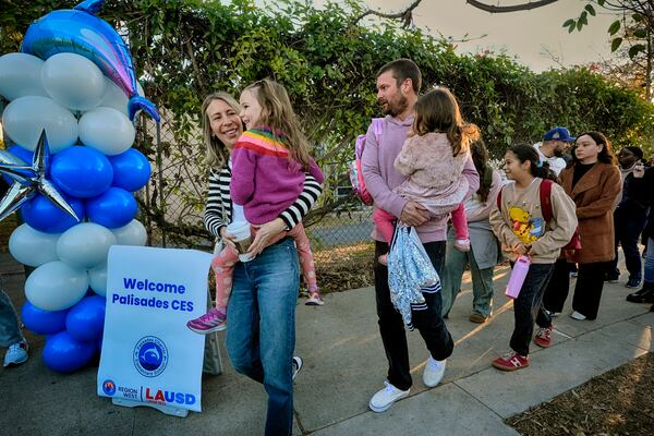 Palisades Charter Elementary School students and their parents arrive at their new school, the Brentwood Elementary Science Magnet school in the Brentwood section of Los Angeles on Wednesday, Jan. 15, 2025. (AP Photo/Richard Vogel)