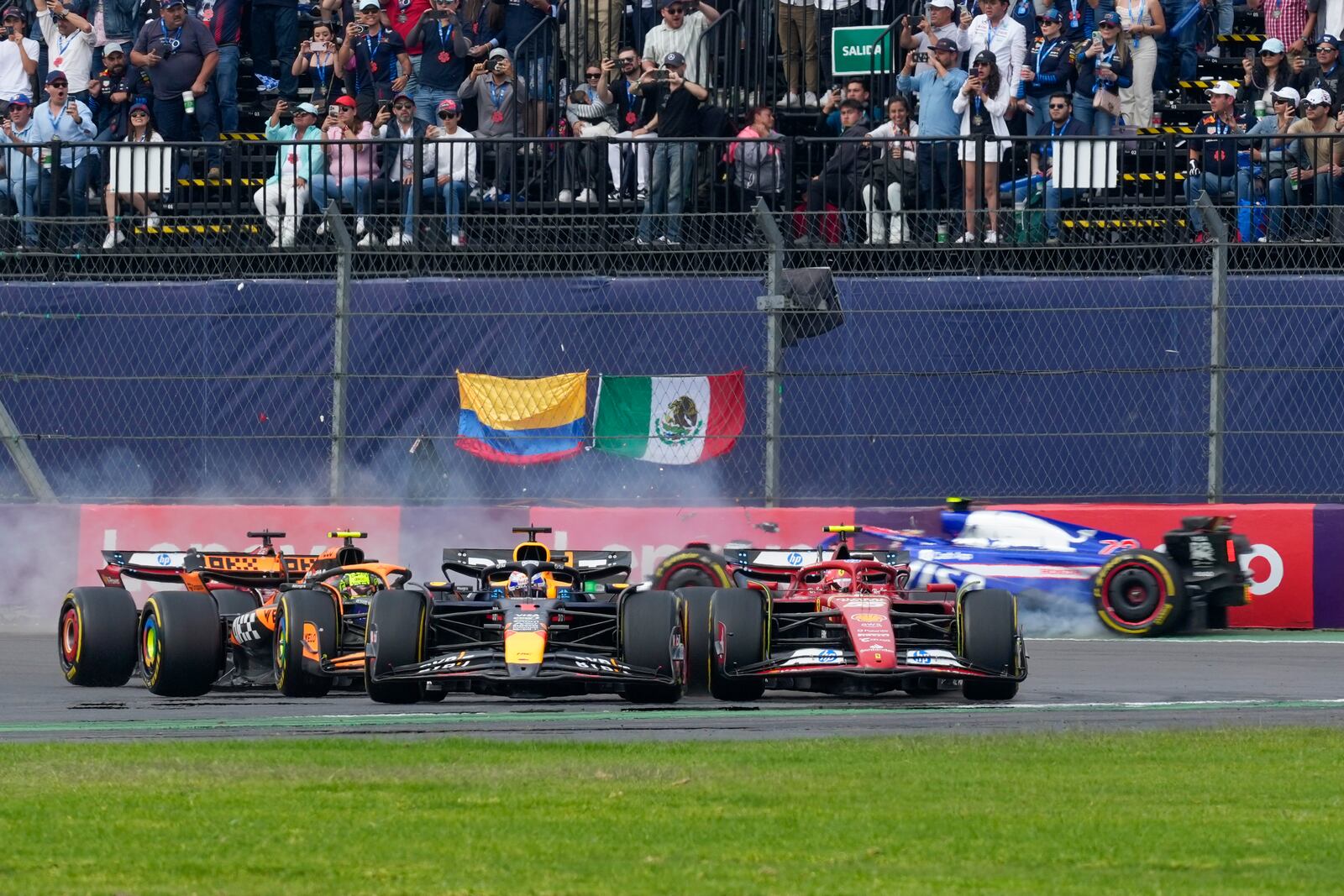 RB driver Yuki Tsunoda of Japan, back, crashes during the Formula One Mexico Grand Prix auto race at the Hermanos Rodriguez racetrack in Mexico City, Sunday, Oct. 27, 2024. (AP Photo/Moises Castillo)