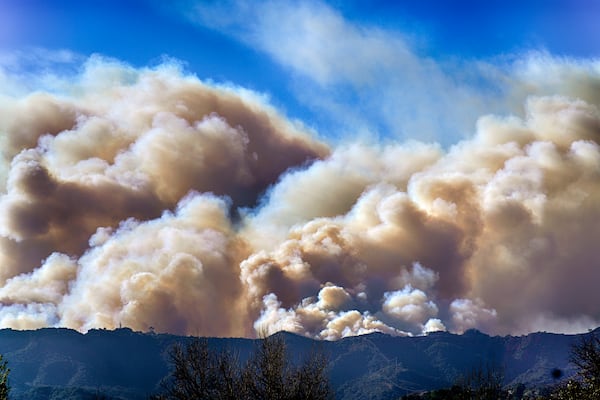 Smoke from the Palisades Fire rises over a ridge as seen from the Encino section of Los Angeles on Saturday, Jan. 11, 2025. (AP Photo/Richard Vogel)