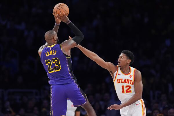 Los Angeles Lakers forward LeBron James, left, shoots as Atlanta Hawks forward De'Andre Hunter defends during the second half of an NBA basketball game, Friday, Jan. 3, 2025, in Los Angeles. (AP Photo/Mark J. Terrill)