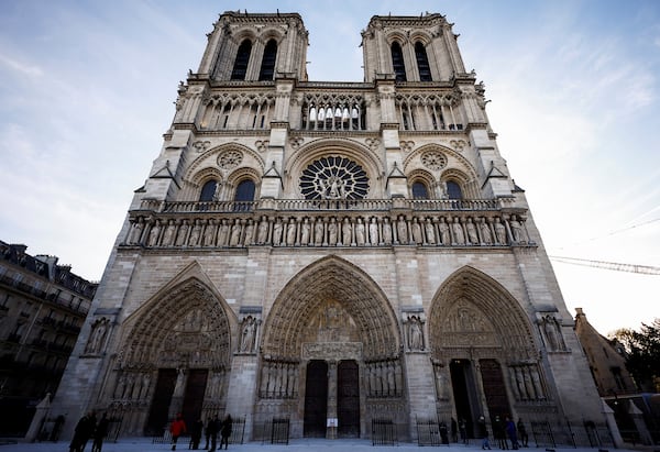 People stand outside Notre-Dame Cathedral in Paris, Friday Nov. 29 2024 before French President Emmanuel Macron's final visit to the construction site to see the restored interiors before the iconic monument's reopening for worship on Dec. 8. (Sarah Meyssonnier, Pool via AP)