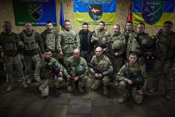 In this photo provided by the Ukrainian Presidential Press Office, Ukrainian President Volodymyr Zelenskyy, center, poses for a photo surrounded by soldiers in the frontline city of Kupiansk, the site of heaviest battles with the Russian troops in the Kharkiv region, Ukraine, Monday, Nov. 18, 2024. (Ukrainian Presidential Press Office via AP)