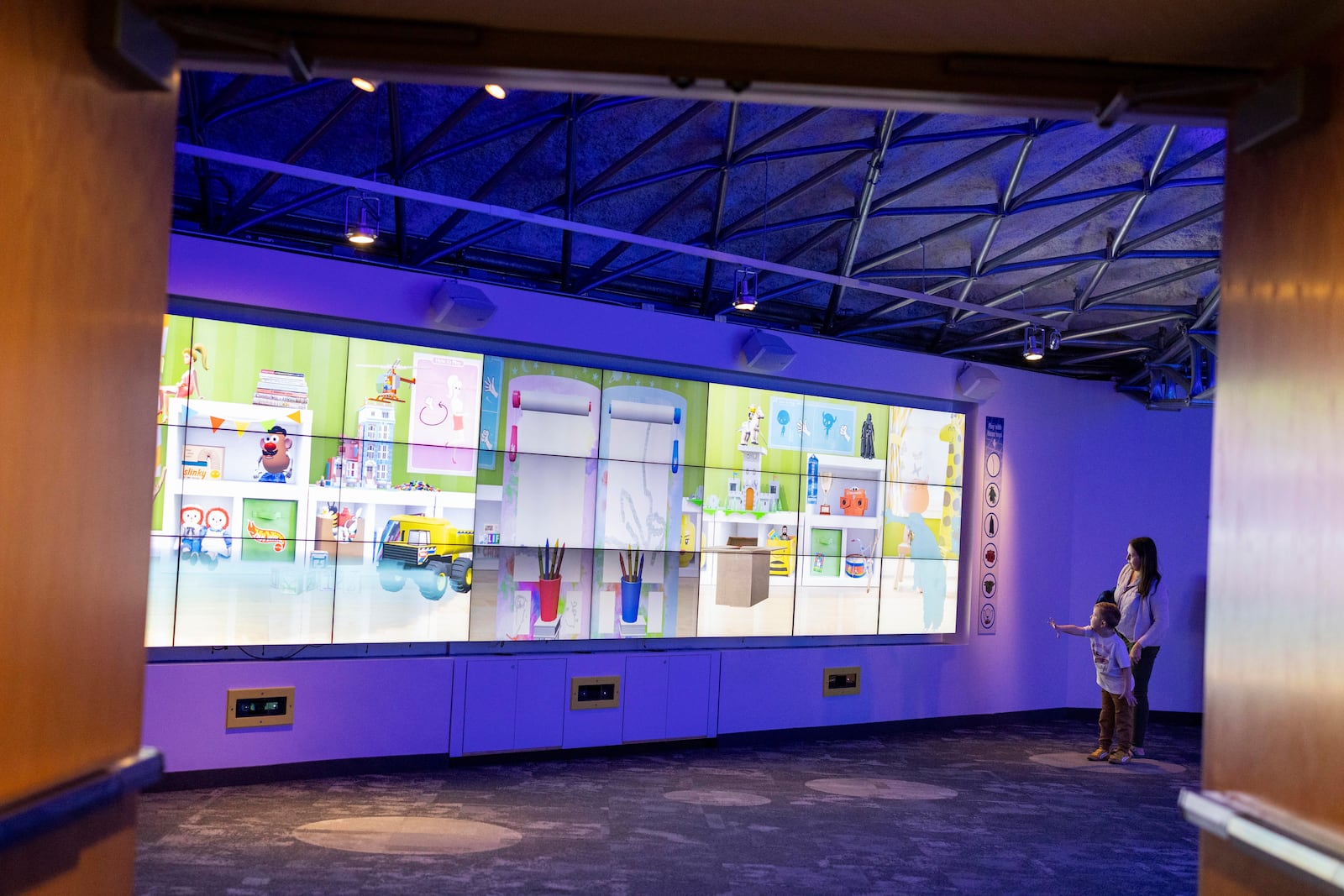 Katie and Henry Liggett play with an interactive game while visiting The Strong National Museum of Play, Tuesday, Oct. 15, 2024, in Rochester, N.Y. (AP Photo/Lauren Petracca)