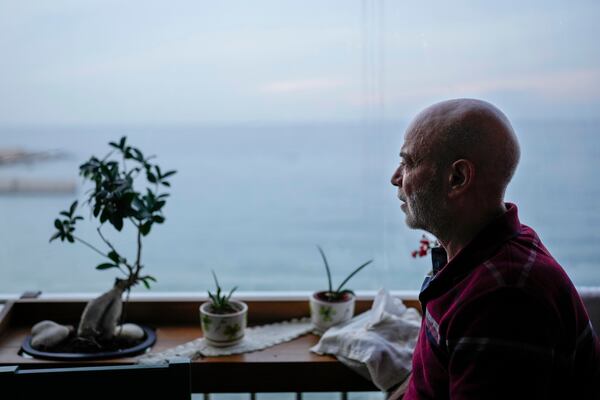 Suheil Hamwi, who spent 32 years in a prison in Syria and returned to Lebanon after the government of Bashar Assad was toppled, sits on the balcony of his home watching the sea in Chekka, Lebanon, Tuesday, Dec. 10, 2024. (AP Photo/Hassan Ammar)