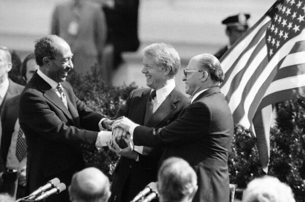 FILE - Egyptian President Anwar Sadat, left, President Jimmy Carter, center, and Israeli Prime Minister Menachem Begin clasp hands to symbolize their agreement after signing the Middle East Peace Treaty at the White House in Washington, March 27, 1979. (AP Photo, File)