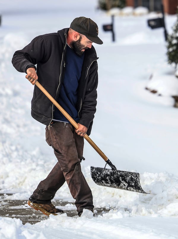 Joe Huff with "The Yard Barber" shovels snow while clearing a driveway for a customer, Saturday, Jan. 11, 2025, in Owensboro, Ky. (Greg Eans//The Messenger-Inquirer via AP)