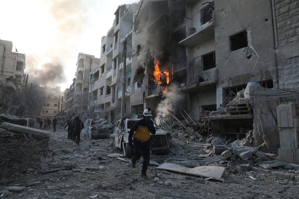 This photo provided by the Syrian Civil Defence White Helmets, which has been authenticated based on its contents and other AP reporting, shows a Syrian White Helmet civil defence worker running in a destroyed neighborhood after the Syrian government forces hit Idlib city, Syria, Monday, Dec. 2, 2024. (Syrian Civil Defence White Helmets via AP)