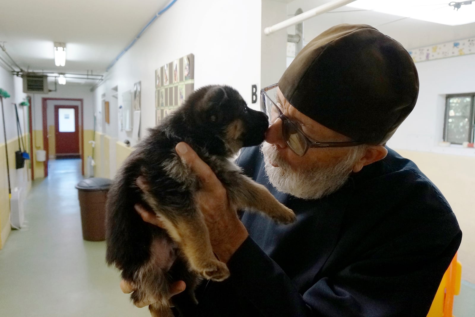 Brother Luke, an Orthodox Christian monk, holds a five-week-old German shepherd puppy from the latest litter in the dog breeding program that for decades has provided both financial and spiritual support to the New Skete monastery outside Cambridge, N.Y., on Oct. 12, 2024. (AP Photo/Giovanna Dell’Orto)