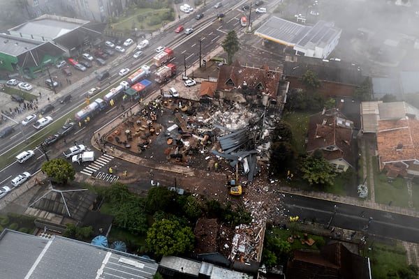 Police carry out an investigation by houses that were hit by a plane in Gramado, Rio Grande do Sul state, Brazil, Sunday, Dec. 22, 2024. (AP Photo/Mateus Bruxel, Agência RBS)