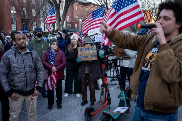 People protest against a funding freeze of federal grants and loans following a push from President Donald Trump to pause federal funding near to the White House in Washington, Tuesday, Jan. 28, 2025. (AP Photo/Ben Curtis)