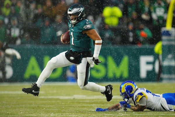 Philadelphia Eagles quarterback Jalen Hurts (1) runs with the ball past Los Angeles Rams cornerback Cobie Durant (14) during the first half of an NFL football NFC divisional playoff game Sunday, Jan. 19, 2025, in Philadelphia. (AP Photo/Derik Hamilton)