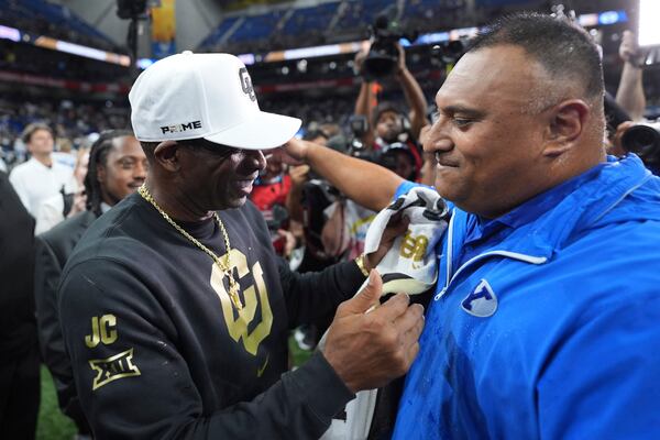 Colorado head coach Deion Sanders, left, and BYU head coach Kalani Sitake, right, meet at midfield following BYU's win in the Alamo Bowl NCAA college football game, Saturday, Dec. 28, 2024, in San Antonio. (AP Photo/Eric Gay)