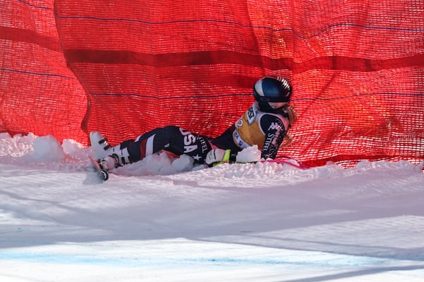 United States' Lindsey Vonn lies on the snow after crashing during an alpine ski, women's World Cup downhill training, in Cortina d'Ampezzo, Italy, Thursday, Jan. 16, 2025. (AP Photo/Marco Trovati)