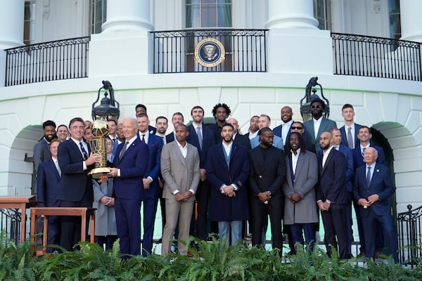 Boston Celtics owner Wyc Grousbeck, from left, and President Joe Biden hold up the Boston Celtics trophy as they pose for a team photo to celebrate the Celtics victory in the 2024 National Basketball Association Championship during an event on the South Lawn of the White House in Washington, Thursday, Nov. 21, 2024. (AP Photo/Susan Walsh)