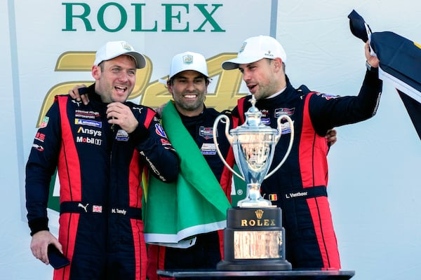 Porsche Penske Motorsport team members, from left to right, Britain's Nick Tandy, Brazil's Felipe Nasr and Belgium's Laurens Vanthoor celebrate after winning the IMSA Rolex 24 hour auto race at Daytona International Speedway, Sunday, Jan. 26, 2025, in Daytona Beach, Fla. (AP Photo/John Raoux)