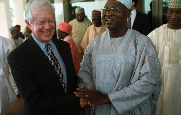 FILE - Nigerian head of state Gen. Abdulsalami Abubakar shakes hands with former U.S. President Jimmy Carter after a meeting at the Nigerian Presidential Villa in the capital Abuja, on Feb. 28, 1999. (AP Photo/Danny Wilcox Frazier, File)