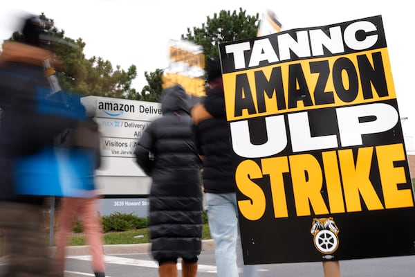 Strikers hold signs during a strike at Skokie (DIL7) Amazon Delivery station in Skokie, Ill., Thursday, Dec. 19, 2024. (AP Photo/Nam Y. Huh)