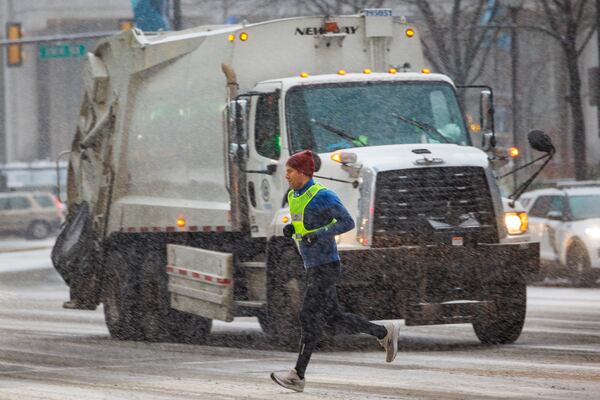 A runner passes on a snowy morning as it falls over Center City, Philadelphia, Monday, Jan. 6, 2025. (Alejandro A. Alvarez/The Philadelphia Inquirer via AP)