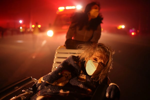 A resident of a senior center is evacuated as the Eaton Fire approaches Tuesday, Jan. 7, 2025 in Altadena, Calif. (AP Photo/Ethan Swope)