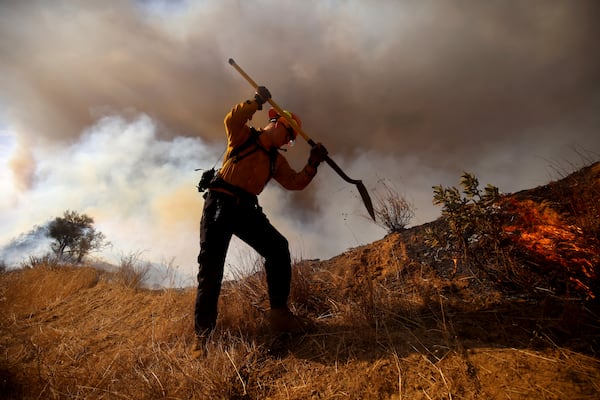 A firefighter works to control the spread of the Hughes Fire in Castaic, Calf., Wednesday, Jan. 22, 2025. (AP Photo/Ethan Swope)