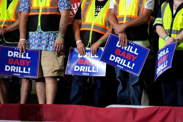 FILE - Attendees holding signs listen as Republican presidential nominee former President Donald Trump speaks during a campaign event, Aug. 29, 2024, in Potterville, Mich. (AP Photo/Alex Brandon, File)