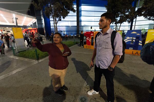 Martha Rosales, left, talks with a migrant from El Salvador who will stay at Rosales' home while waiting an appointment to apply for asylum in the United States through the CBP One app Wednesday, Aug. 28, 2024, in Tijuana, Mexico. (AP Photo/Gregory Bull)