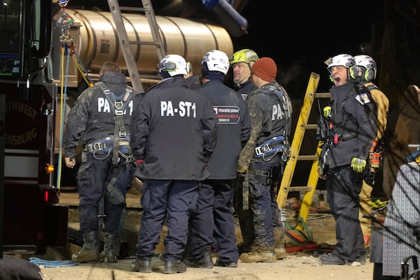 Rescue workers search through the night in a sinkhole for Elizabeth Pollard, who disappeared while looking for her cat, in Marguerite, Pa., Tuesday, Dec. 3, 2024. (AP Photo/Gene J. Puskar)