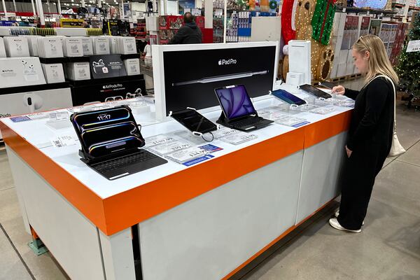 FILE - A consumer looks over an IPad on display in a Costco warehouse Friday, Nov. 1, 2024, in Sheridan, Colo. (AP Photo/David Zalubowski, File)