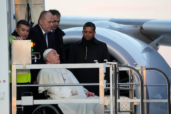 Pope Francis boards an airplane at Rome's Fiumicino, airport as he leaves for his one-day visit to Ajaccio in he French island of Corsica, Sunday, Dec.15, 2024. (AP Photo/Gregorio Borgia)