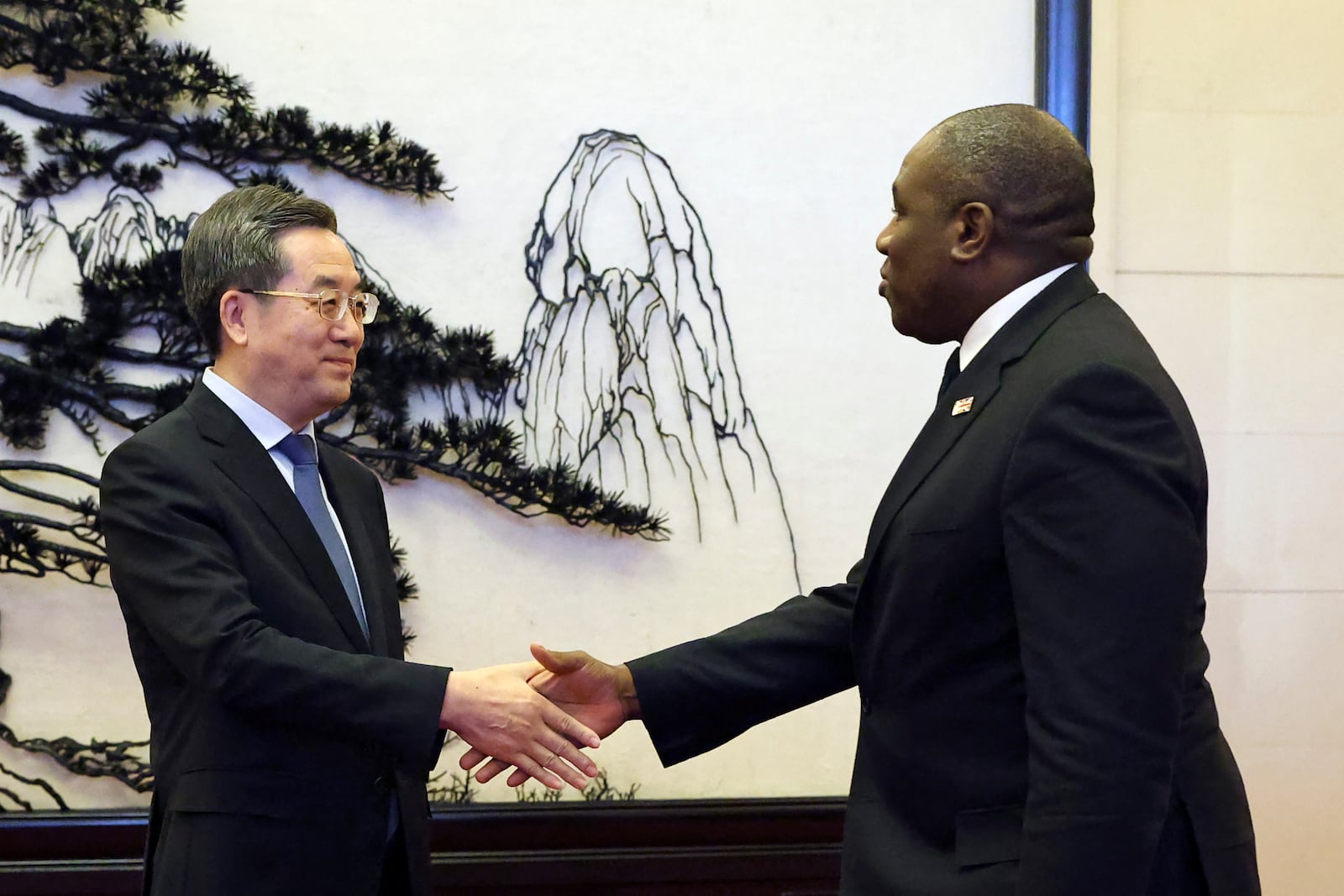 Britain's Foreign Secretary David Lammy, right, and Chinese Vice Premier Ding Xuexiang shake hands before their meeting at the Great Hall of the People in Beijing Friday, Oct. 18, 2024. (Florence Lo/Pool Photo via AP)