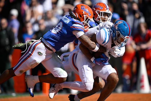 Mississippi wide receiver Tre Harris (9) scores a touchdown against Florida defensives back Bryce Thornton, left, and Dijon Johnson, rear, on a 43-yard pass play during the first half of an NCAA college football game, Saturday, Nov. 23, 2024, in Gainesville, Fla. (AP Photo/Phelan M. Ebenhack)