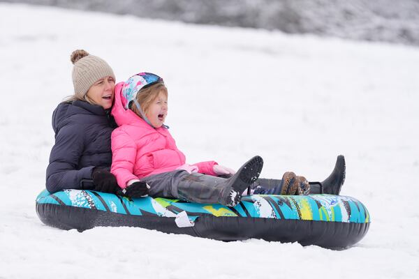 People sled down a snow covered hill Saturday, Jan. 11, 2025, in Nashville, Tenn. (AP Photo/George Walker IV)