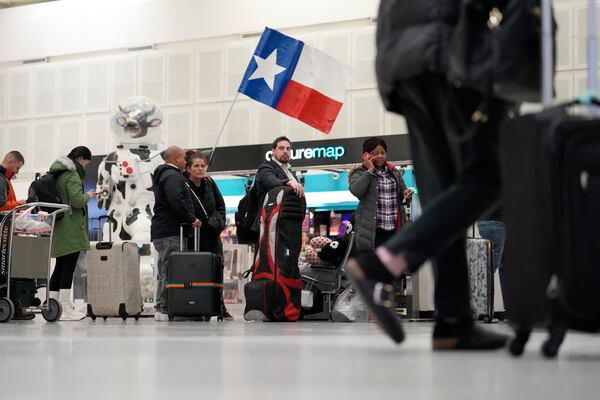 Passengers wait to check-in for their flights at George Bush Intercontinental Airport Monday, Jan. 20, 2025, in Houston, ahead of a winter storm that is expected to bring several inches of snow and will close both of Houston's airports on Tuesday. (AP Photo/David J. Phillip))