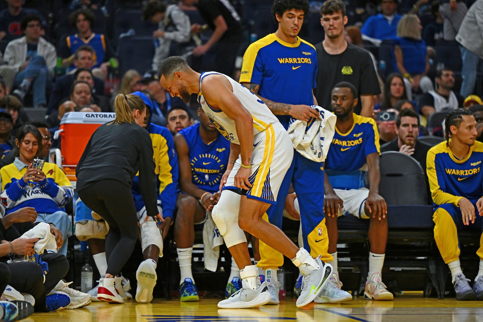 Golden State Warriors' Stephen Curry, center front, hobbles off the court after sustaining an injury to his left ankle in the fourth quarter of an NBA basketball game against the Los Angeles Clippers in San Francisco, Sunday, Oct. 27, 2024. (Jose Carlos Fajardo/Bay Area News Group via AP)