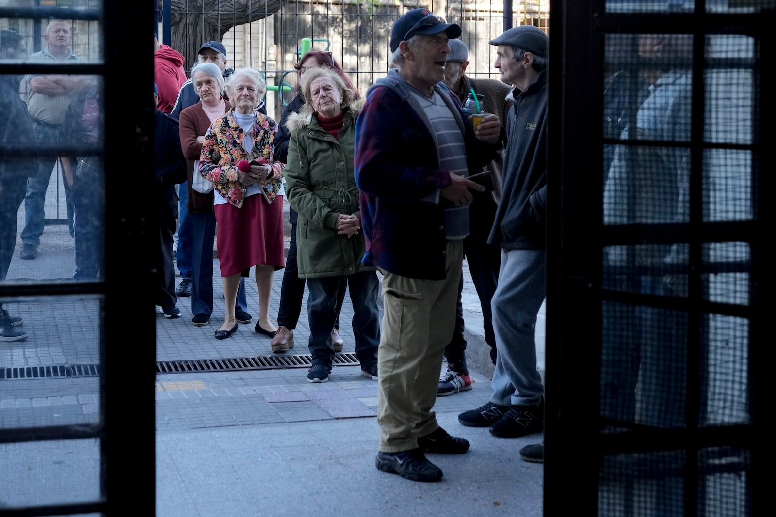 People line up to vote outside a polling station during general elections in Montevideo, Uruguay, Sunday, Oct. 27, 2024. (AP Photo/Natacha Pisarenko)