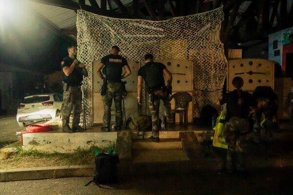 French gendarmes patrol during curfew outside Mamoudzou, Mayotte, Saturday, Dec. 21, 2024. (AP Photo/Adrienne Surprenant)