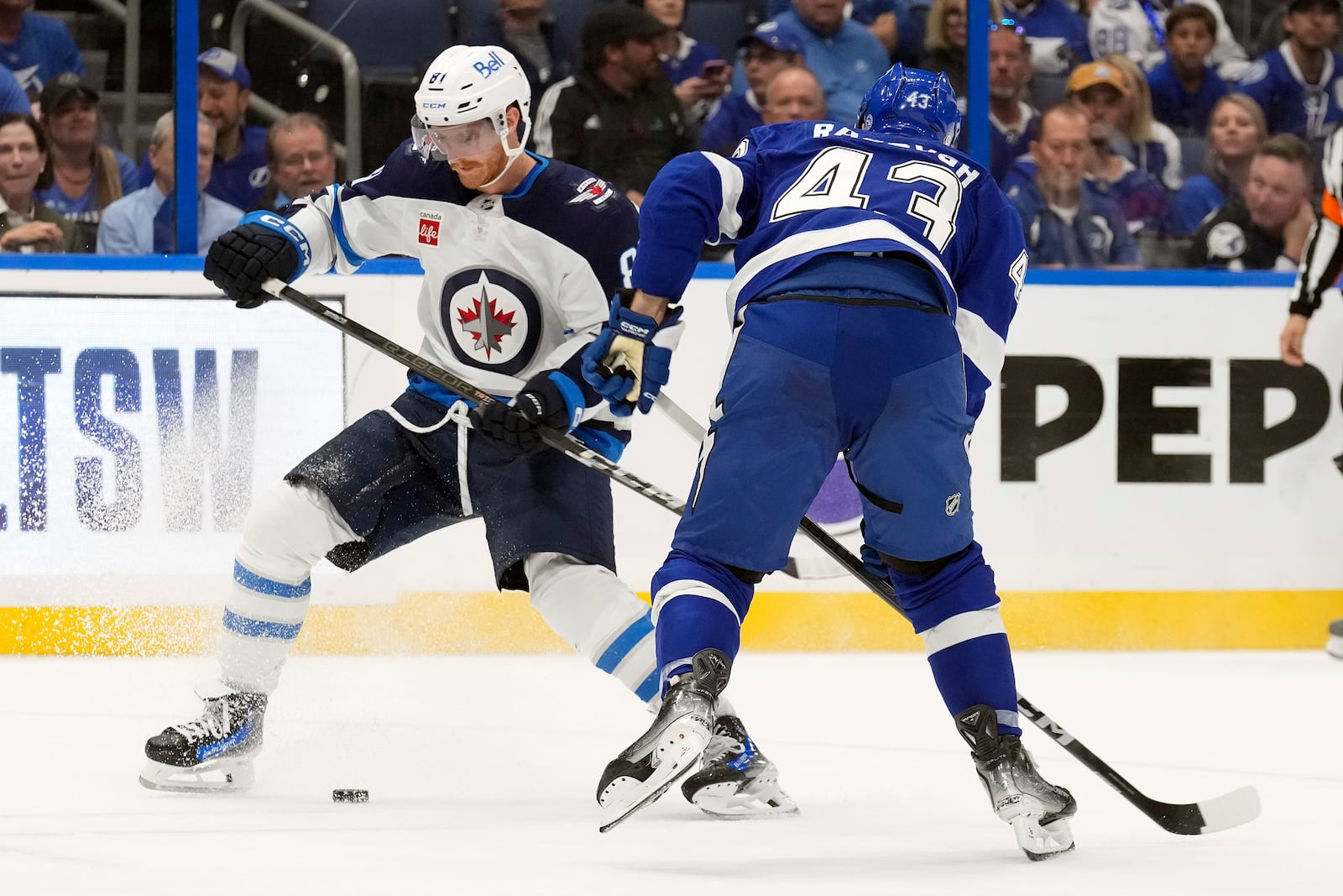 Winnipeg Jets left wing Kyle Connor (81) tries to cut around Tampa Bay Lightning defenseman Darren Raddysh (43) during the third period of an NHL hockey game Thursday, Nov. 14, 2024, in Tampa, Fla. (AP Photo/Chris O'Meara)